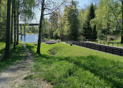 Idyllic spring landscape with a path through lush greenery by a calm river.
